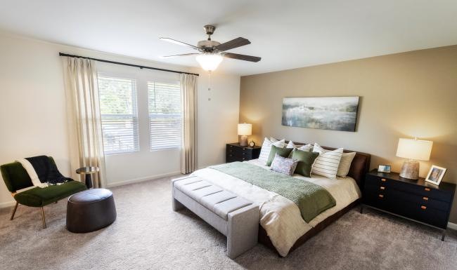 Relax and recharge in beautiful and spacious bedrooms a bedroom with a bed and a fan