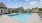 swimming pool with lounge chairs and a building in the background