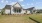 a house with a large yard and light grey paneling