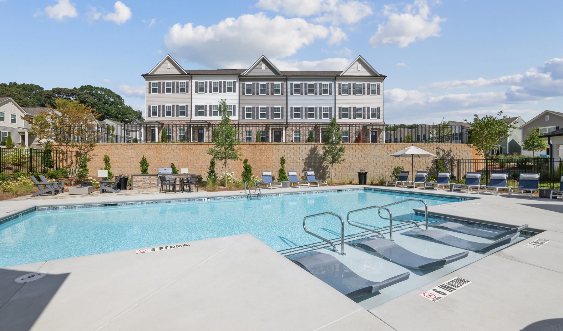 resort style swimming pool with lounge chairs and grilling stations